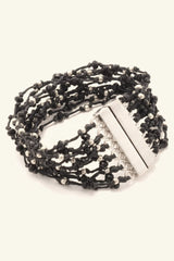 Black beaded bracelet with a silver clasp on a white background