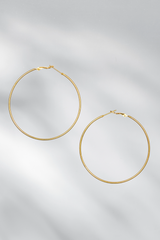 Gold hoop earrings on a light gray background