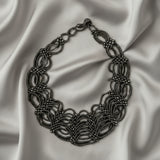 Silver necklace on a dark gray background