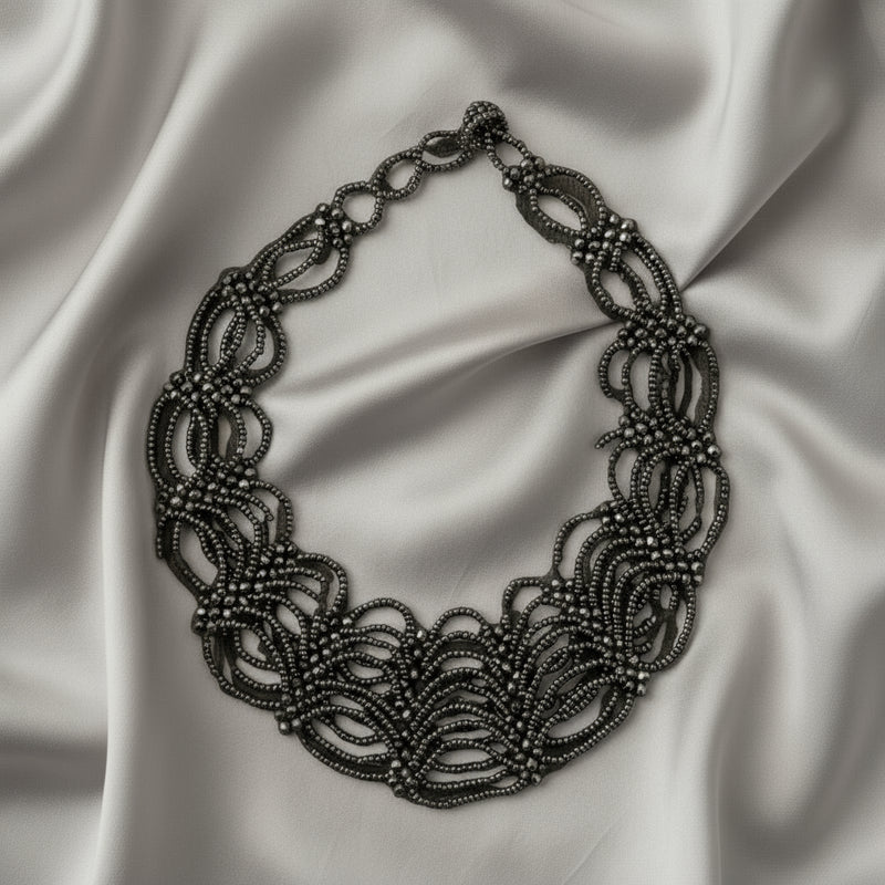 Silver necklace on a dark gray background