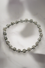 Silver floral bracelet on a light gray background