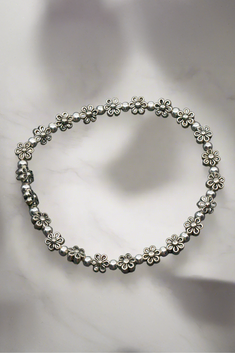 Silver floral bracelet on a light gray background